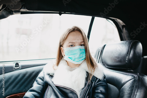 Young woman in a car in a medical mask, preventive measures for an epidemic. © velimir