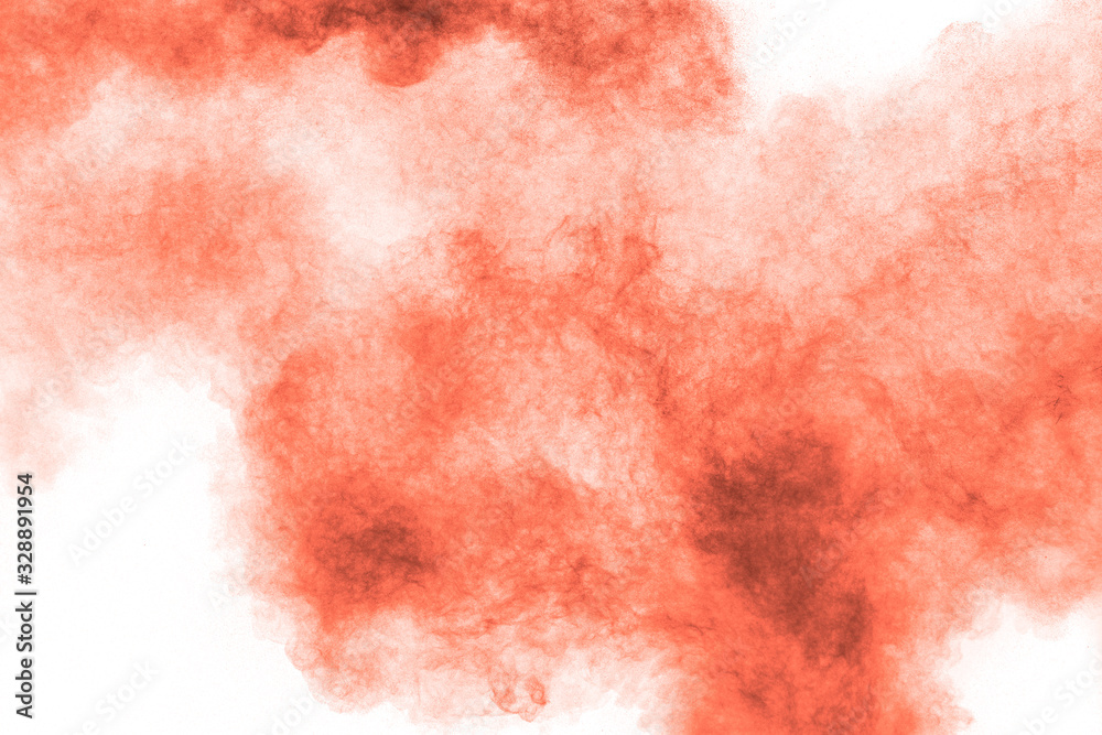 Abstract explosion of orange dust on white background.Freeze motion of orange powder splashing.