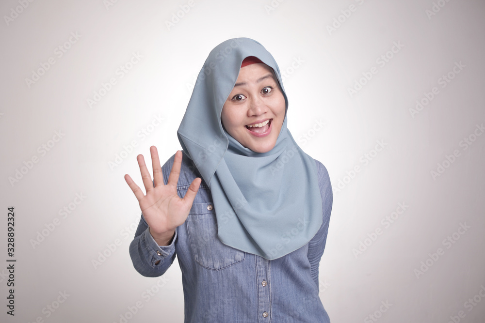 Muslim Woman Smiling at Camera with Number Five or Saying Hi Gesture Muslim Woman Smiling at Camera with Number Five or Saying Hi Gesture