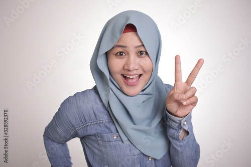Muslim Woman Smiling and Shows Number Two or Peace Sign Gesture
