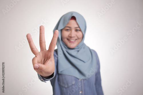 Muslim Woman Smiling and Shows Number Three Sign Gesture