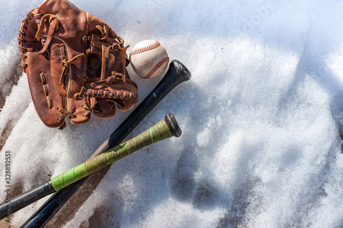 Baseball in spring. Melting snow with Baseball and Baseball Bat.  Playing sports in spring.