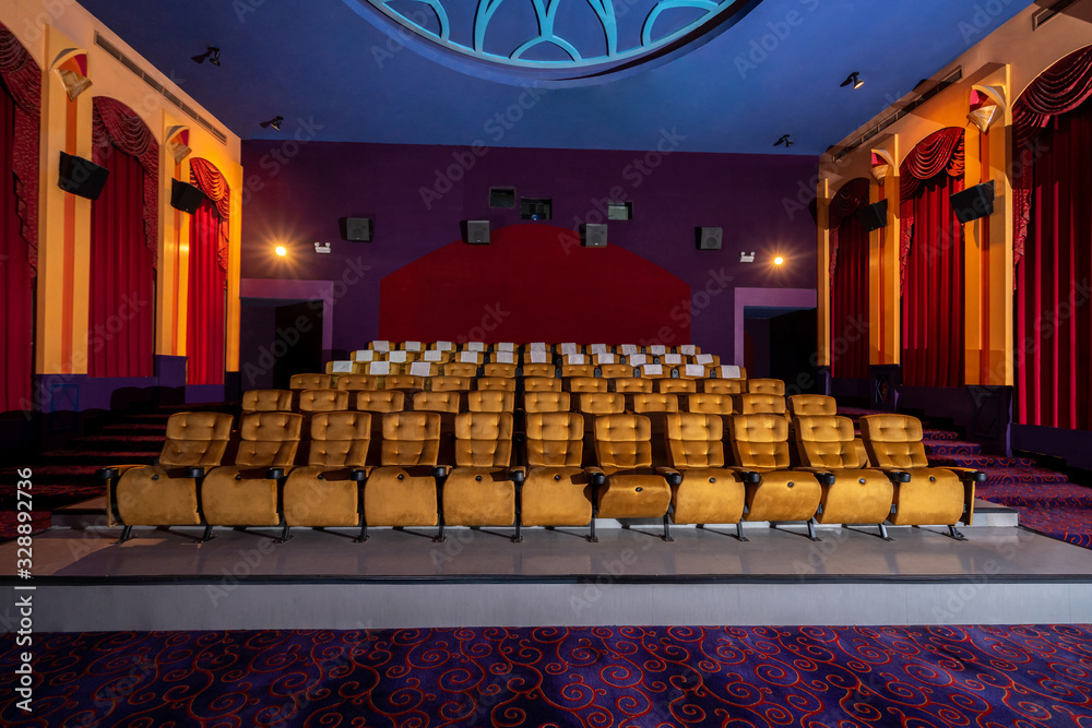 Large cinema theater interior with seat rows for audience to sit in