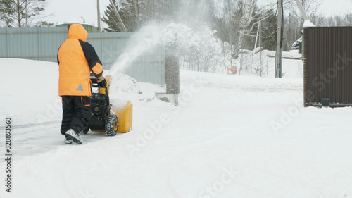 Man cleans snow with a snow thrower