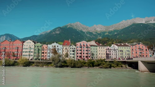 Innsbruck city colord houses trough a fence with a river between on a sunny day 4k photo