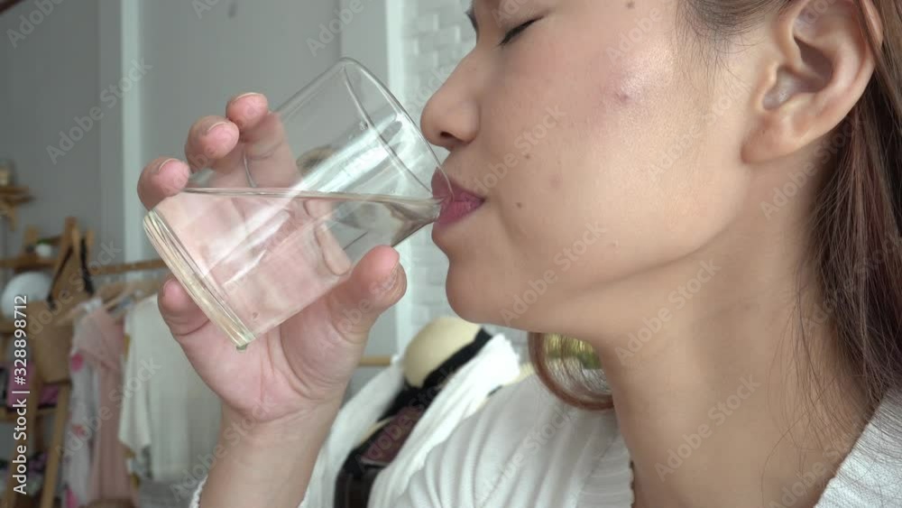 Asian young woman drinking water after wake up in the morning Asian young woman drinking water after wake up in the morning