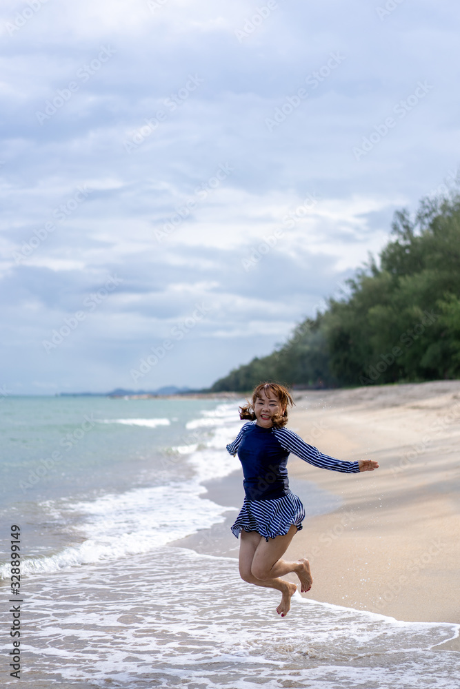 Middle age senior woman is Enjoying and running Summer Vacation on the beach, Thailand.