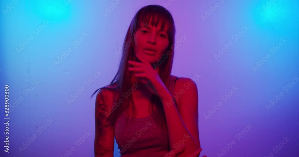 Fashion model girl Turns to the camera and looks in neon light Fashion model girl Turns to the camera and looks in neon light
