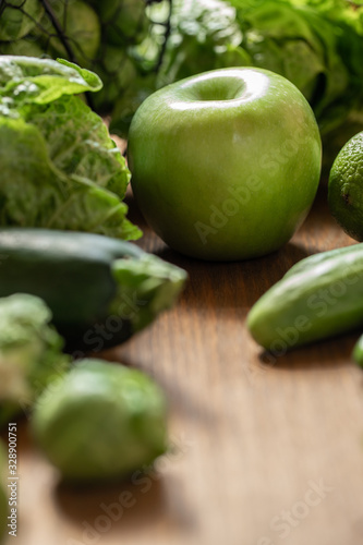 grünes Gemüse und Obst auf brauner Platte aus Holz photo