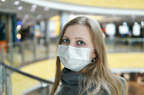 young woman in a surgical mask in a public space