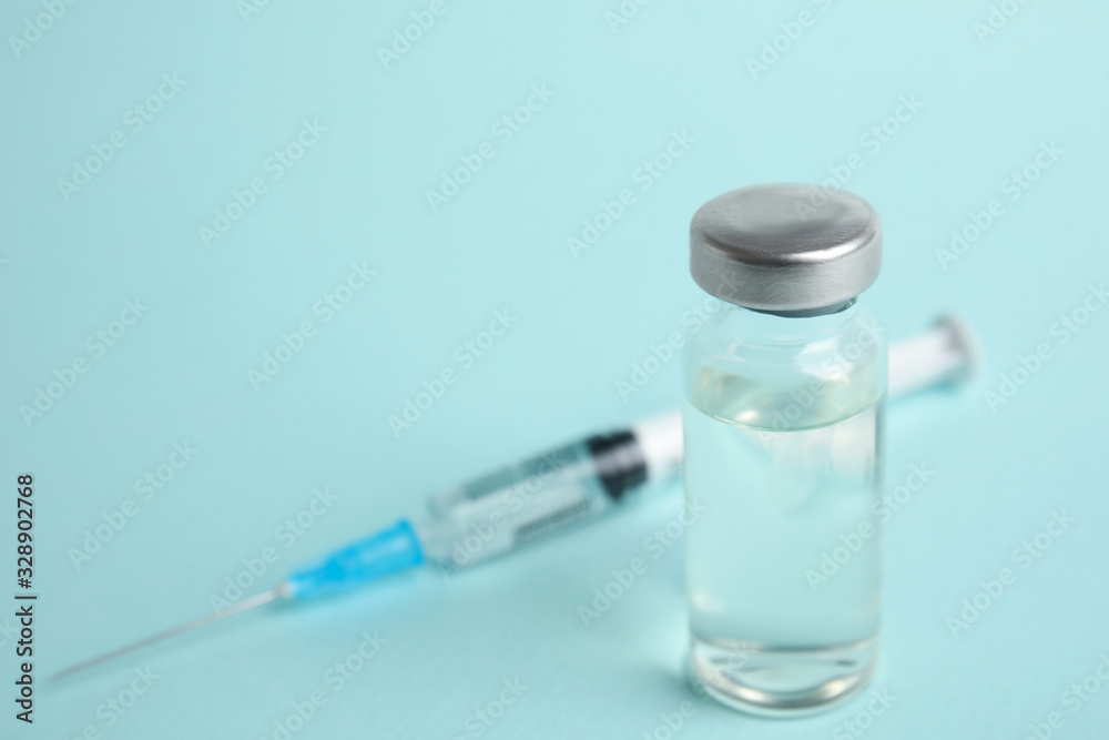 Vial and syringe on turquoise background, space for text. Vaccination and immunization Vial and syringe on turquoise background, space for text. Vaccination and immunization