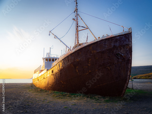 An out-of-the-way whaling ship that wrecked on the beach to Latrabjarg during sunset © Hladchenko Viktor