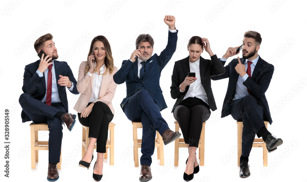 Obraz premium Five businessmen talking, reading and writing on their phones