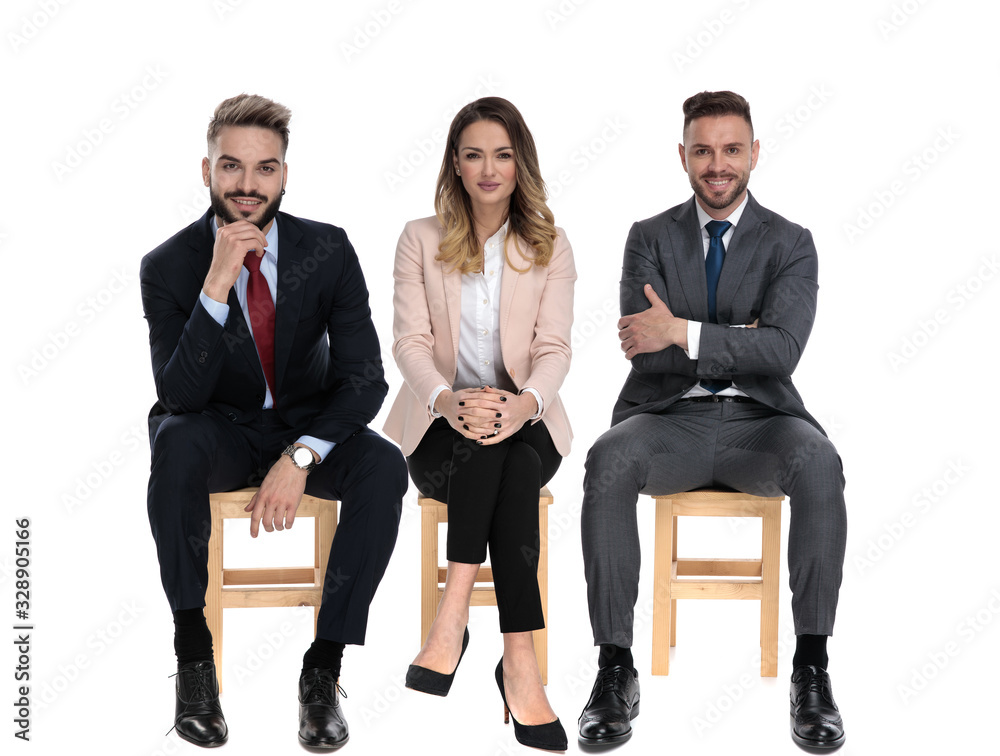Three young businessmen smiling and listening