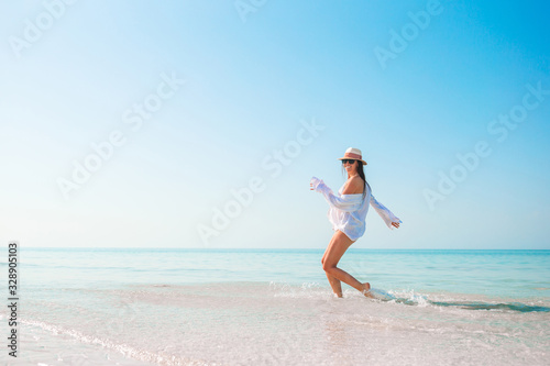 Woman on the beach enjoying summer holidays looking at the sea