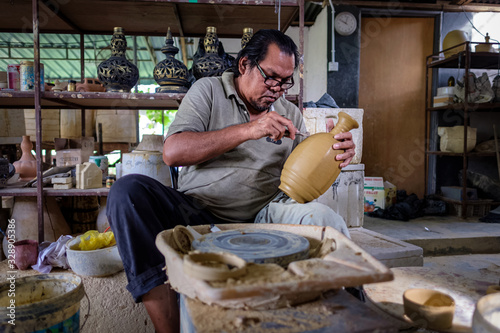 Local craftsman demonstrates on making traditional clay jar called 