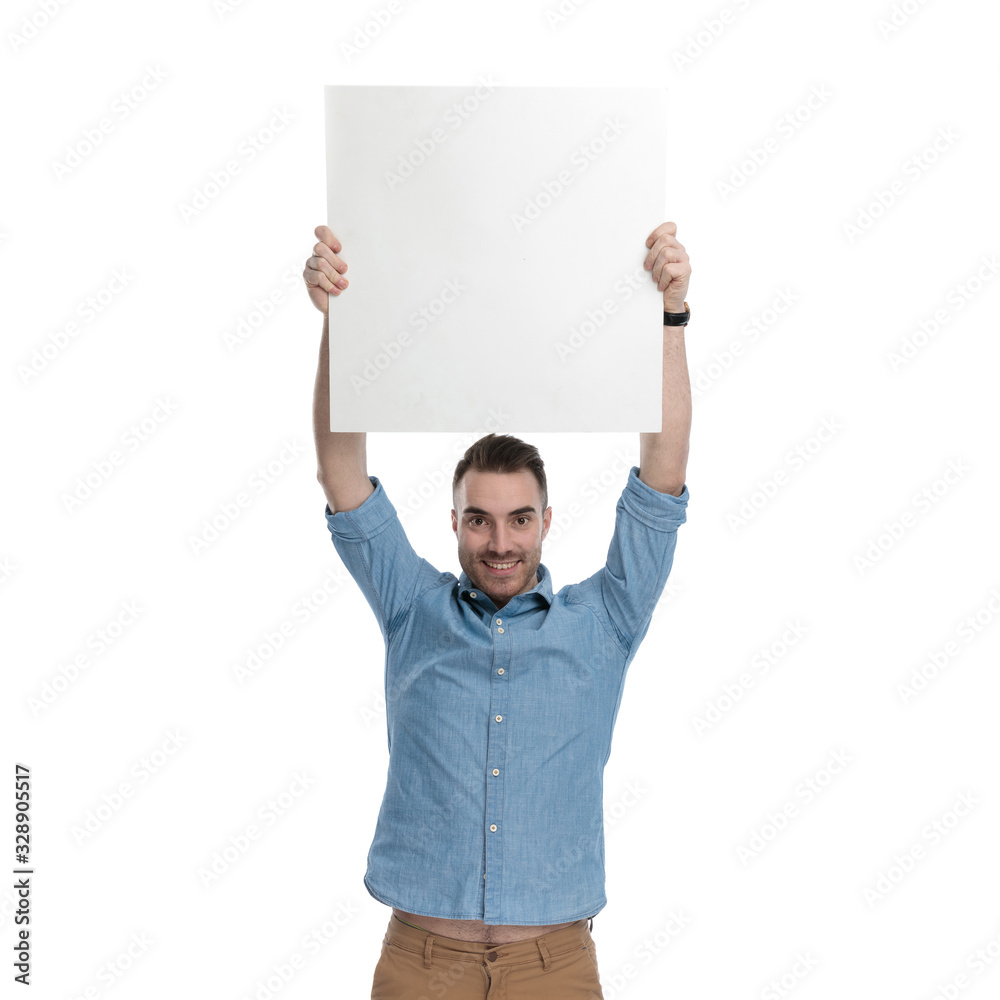 Proud casual man holding empty billboard above his head Proud casual man holding empty billboard above his head