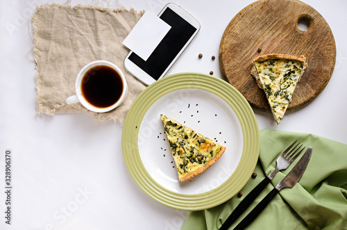 Spinach quiche pie with coffee on white background. Flat lay