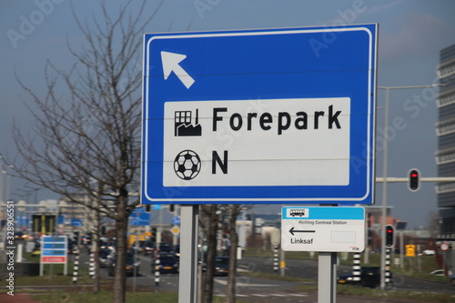 Blue and white direction sign at junction heading to industrial zone Forepark and football stadium direction north in The Hague