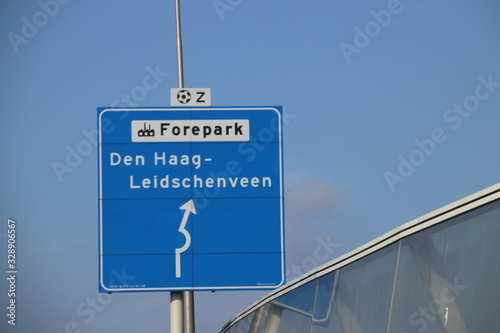 Blue and white direction sign at junction on the A12 The Hague Leidschenveen, industrial area Forepark and football stadium south photo