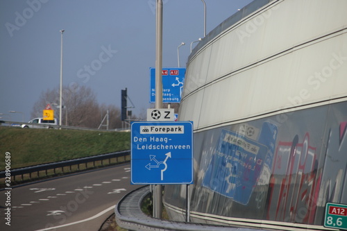 Blue and white direction sign at junction on the A12 The Hague Leidschenveen, industrial area Forepark and football stadium south photo
