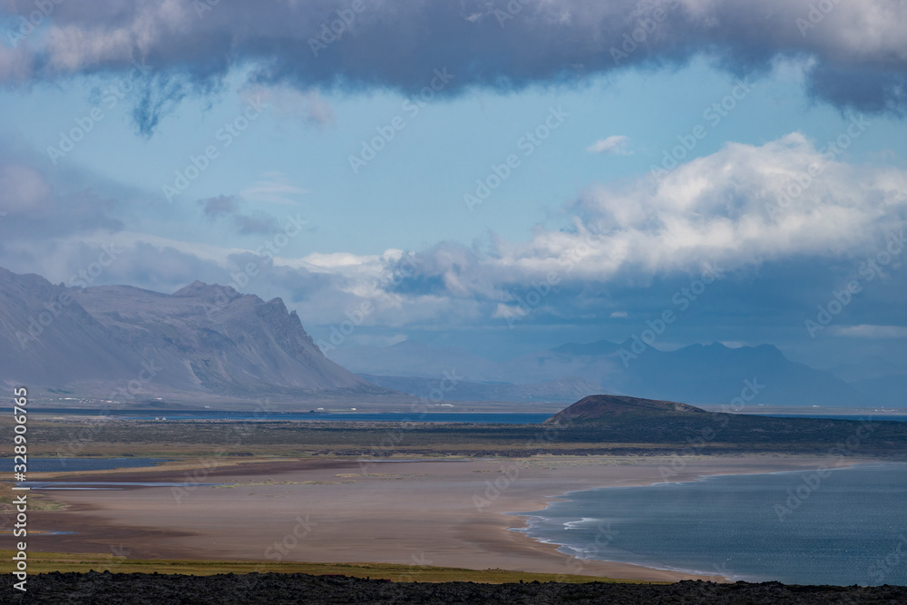Icelandic landscape with mountains, blue sky and green grass on the foreground. West fjord part