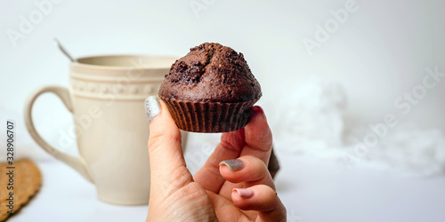 Delicious cupcakes on white table. Girl holding a cupcake