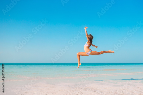 Adorable active little girl at beach during summer vacation