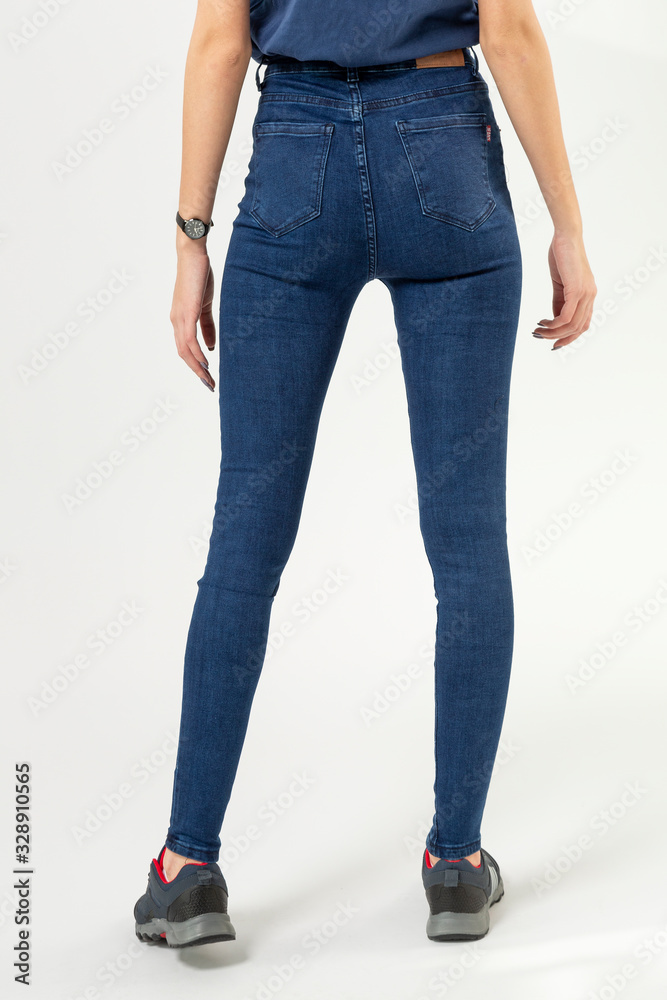 girl in jeans shows off jeans on white background close up, blue jeans girl in jeans shows off jeans on white background close up, blue jeans