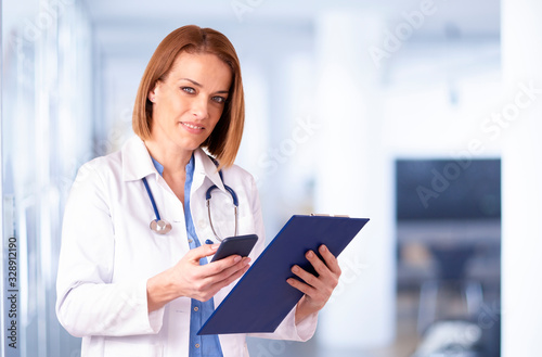 Female doctor portrait while talking with somebody on her mobile phone in the medical center
