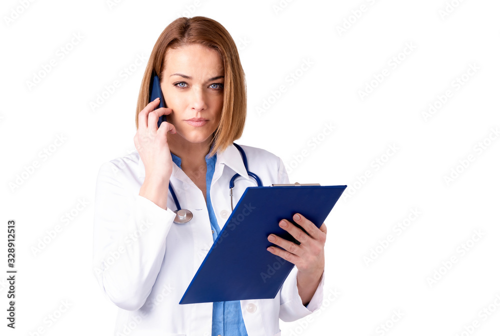 Mature female doctor using her mobile phone while standing at isolated white background Mature female doctor using her mobile phone while standing at isolated white background