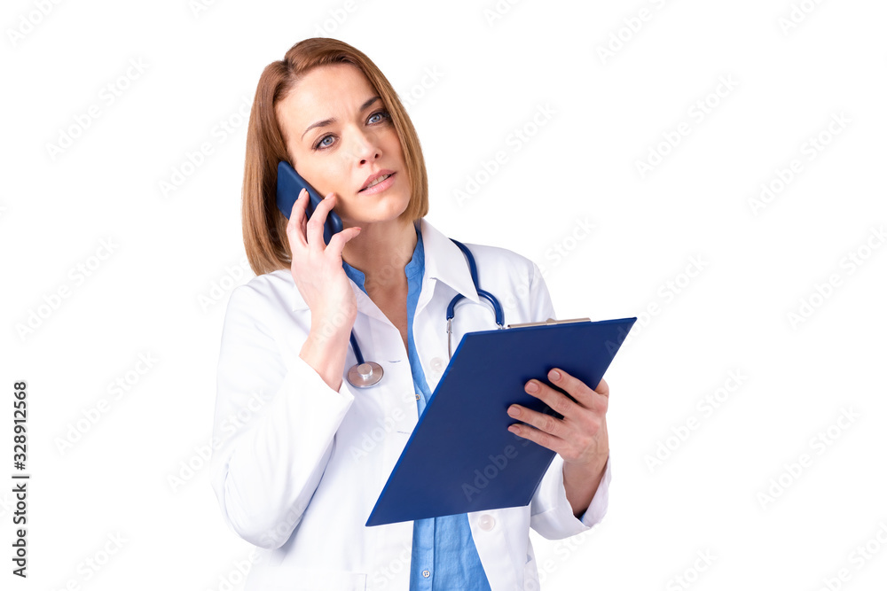 Mature female doctor using her mobile phone while standing at isolated white background Mature female doctor using her mobile phone while standing at isolated white background