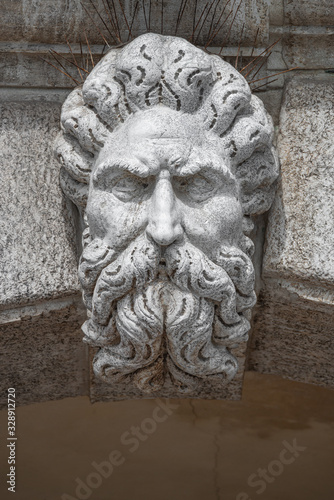 Portrait of ancient aged sculpture of old Venetian bearded man in Venice, Italy, closeup, details