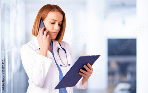 Femal doctor having a call while standing in medical clinic