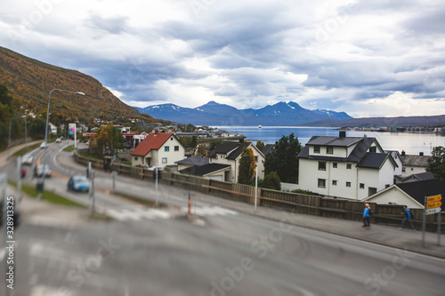 View of Tromso, with cathedral, Tromso Bridge, Tromsoya island, embankment and scenery beyond the city, Troms og Finnmark county, Norway, summer day © tsuguliev