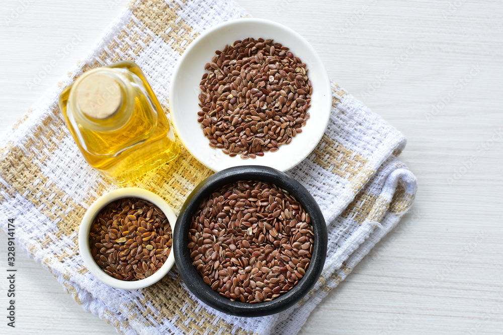 Flaxseed or flaxseed seeds, accompanied by oil (Linum usitatissimum) displayed in containers