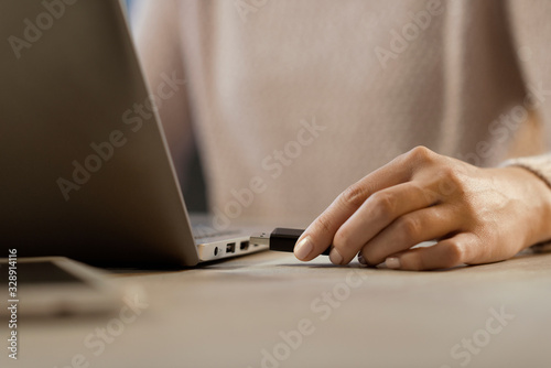 Woman plugging a USB flash drive into her laptop