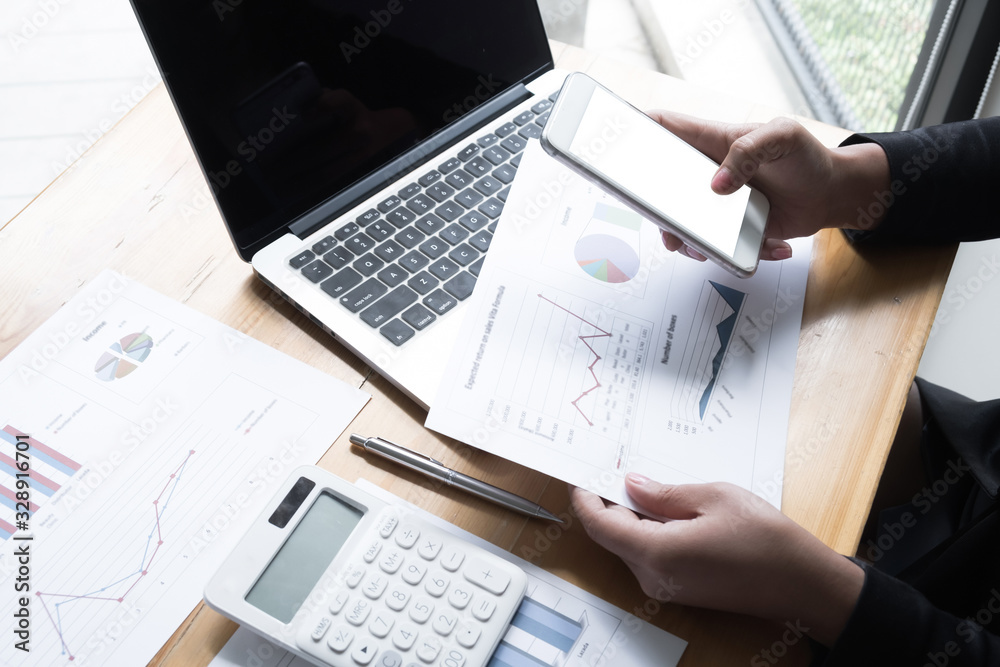 Business woman are discussing about business graph on the table in the office room Business woman are discussing about business graph on the table in the office room