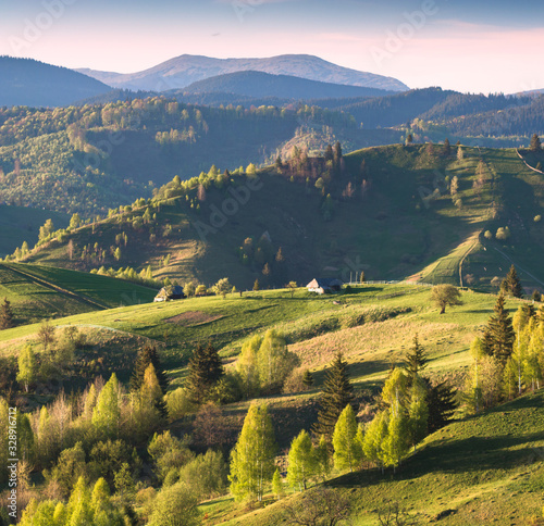 Alpine mountain village on a green rolling hills © Bashkatov