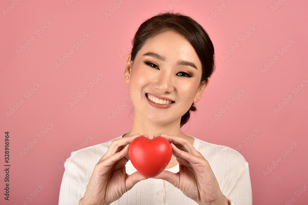 Gentle asian woman holding red heart, Happy smiling girl showing love sign to support and encourage, Cardiac health checkup. Gentle asian woman holding red heart, Happy smiling girl showing love sign to support and encourage, Cardiac health checkup.
