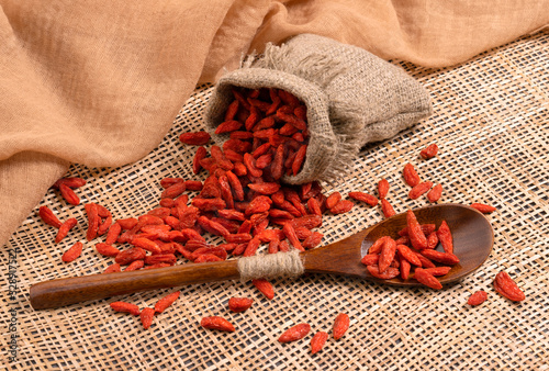 Goji berries on a wooden background in a spoon photo