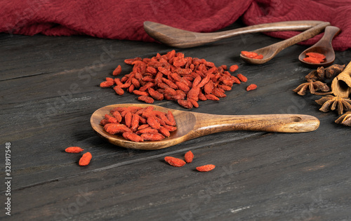 Goji berries on a wooden background in a spoon photo