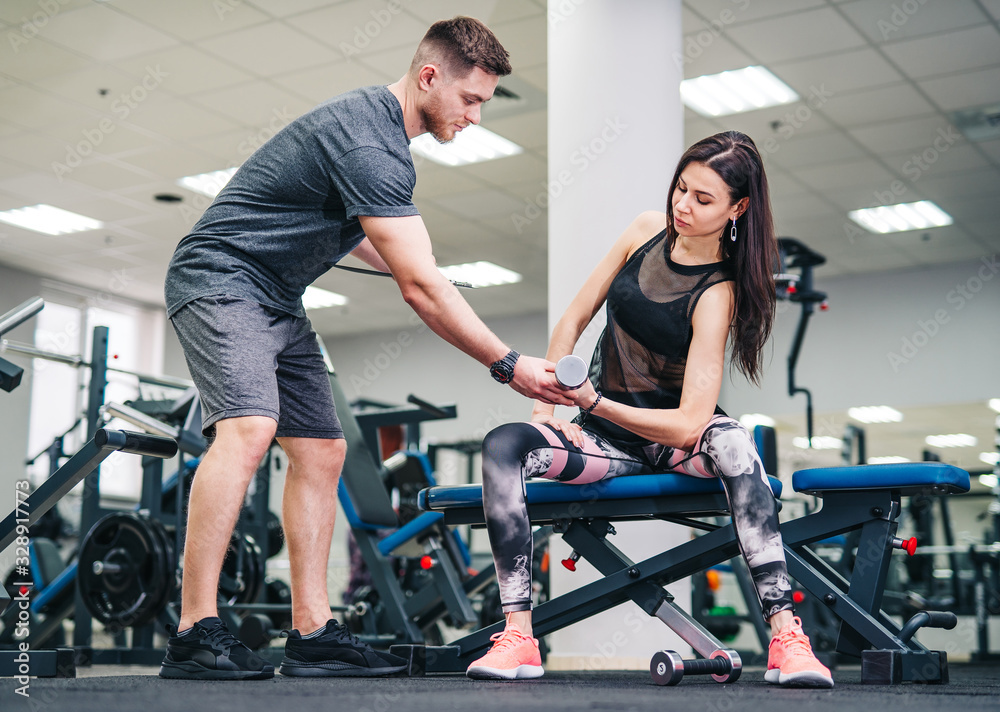 Fit woman working out with trainer at the gym. Athlete and beauty doing workout. Health life sport concept. Fit woman working out with trainer at the gym. Athlete and beauty doing workout. Health life sport concept.