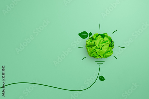 Fototapeta Green crumpled paper light bulb on green background, Corporate Social Responsibi