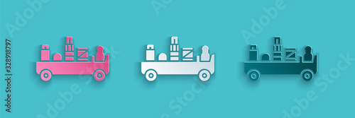 Paper cut Airport luggage towing truck icon isolated on blue background. Airport luggage delivery car. Paper art style. Vector Illustration