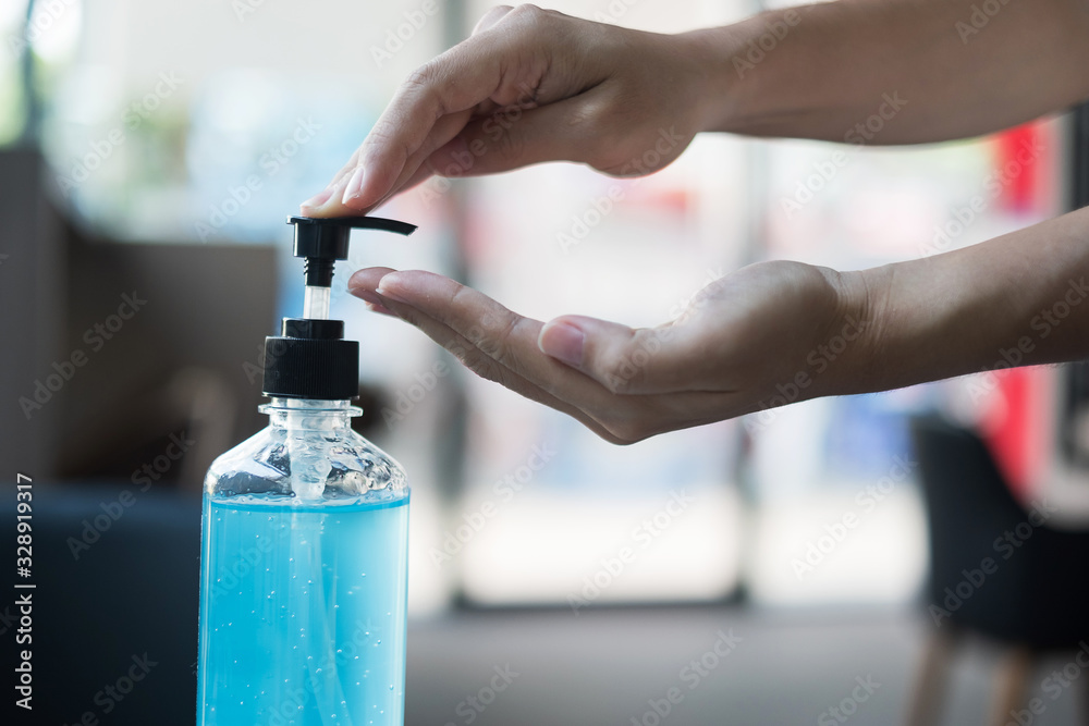 Woman hands using wash hand sanitizer gel dispenser, against Novel coronavirus or Corona Virus Disease (Covid-19) at public train station. Antiseptic, Hygiene and Healthcare concept - obrazy, fototapety, plakaty 