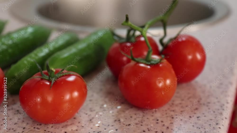 Tomatoes and cucumbers on the kitchen table. The shallow pull