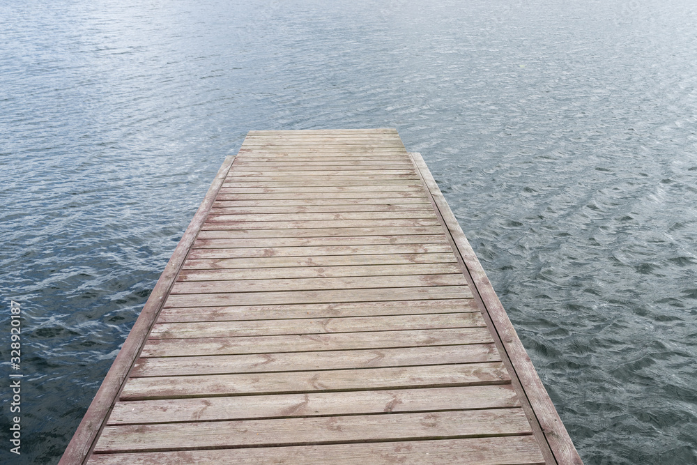 Wooden bridge for swimming on the shore of a lake. Blue water, summer nature landscape.  Environmental concept, Latvia, Europe.