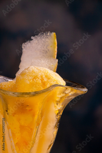 Homemade melon orange fruit sorbet granita popsicles lollies and slices of fresh ripe melon fruit against yellow blue background. summer dessert, sweet snack. close up photo