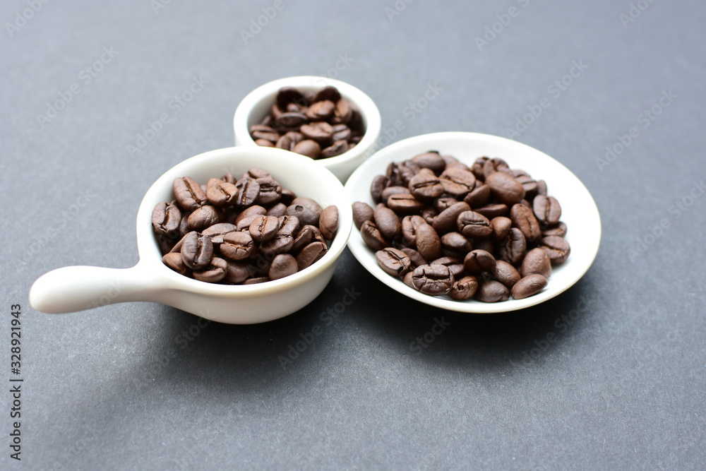 Fototapeta premium Colombian coffee beans, displayed in containers on black background